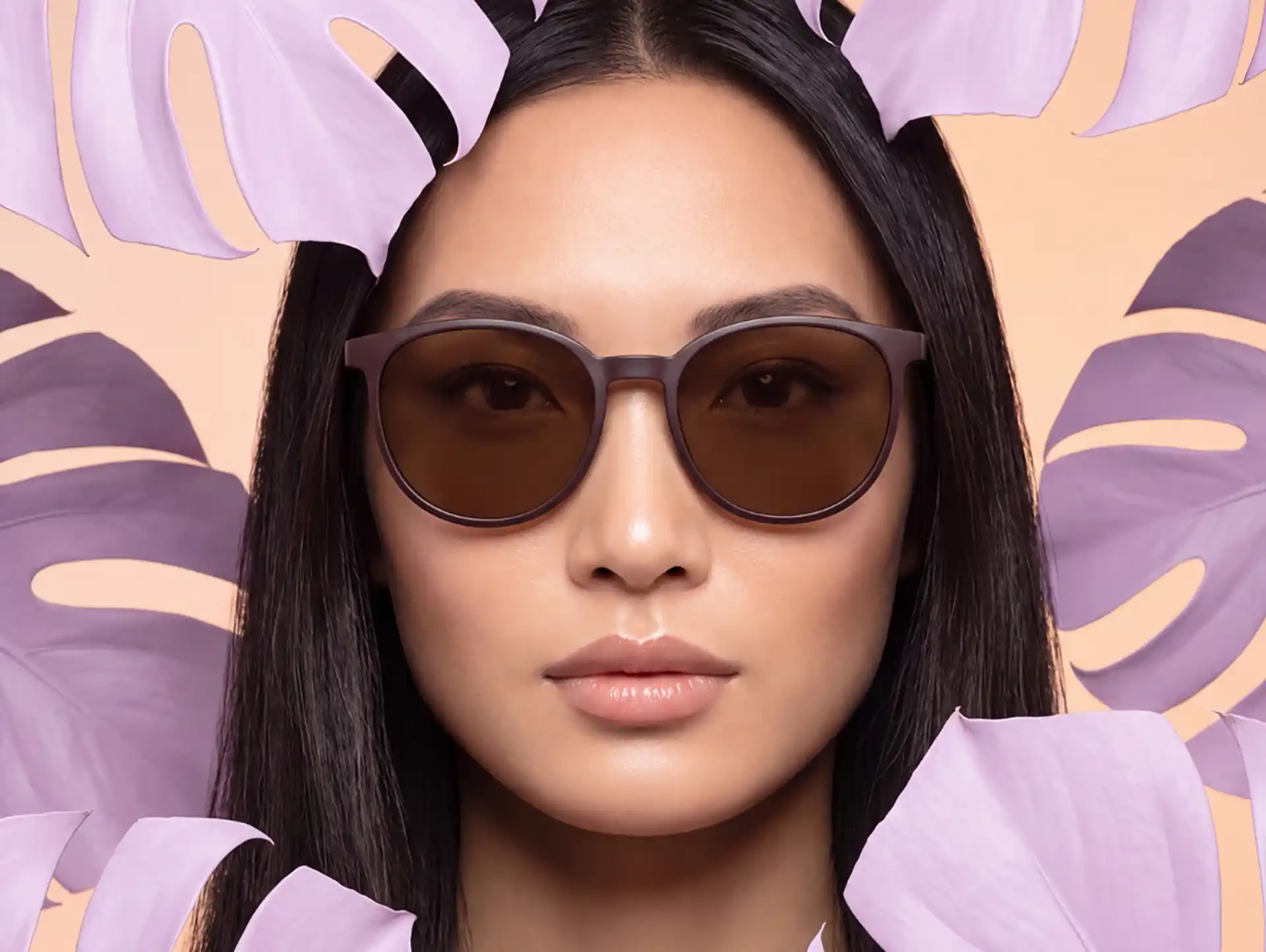 Close-up einer Frau mit runder Sonnenbrille und dunklen Gläsern im sommerlichen Look.